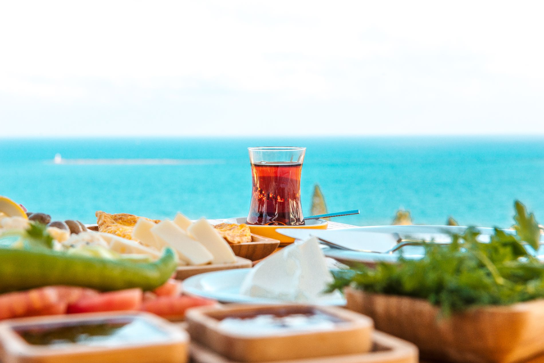 Turkish tea with breakfast on the table in front of sea background landscape