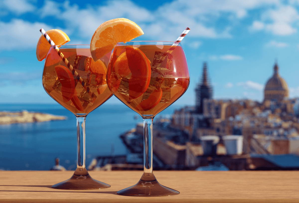 Fruity cocktail drinks sat on the side with a backdrop of the city in Malta