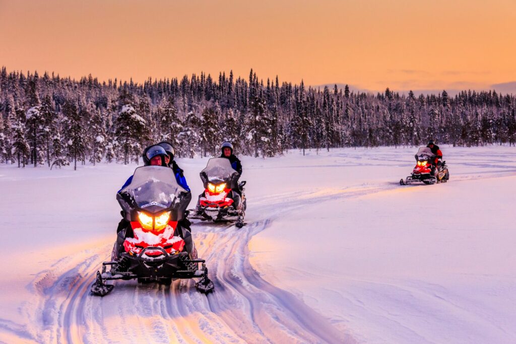 Several people on a snowmobile excursion in Lapland