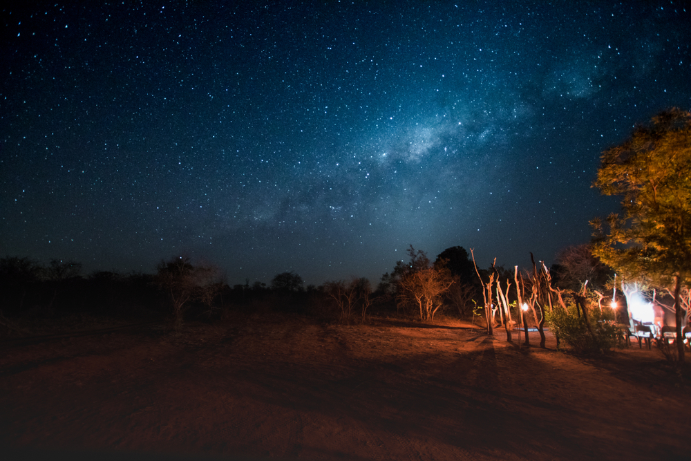 Milky Way over African bush camp with bonfire in Kruger Nationalpark, South Africa