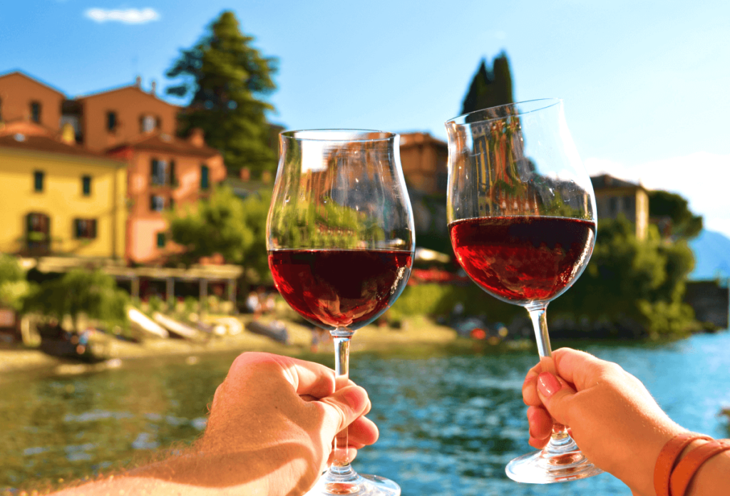 Two glasses of red wine against the backdrop of an Italian lake
